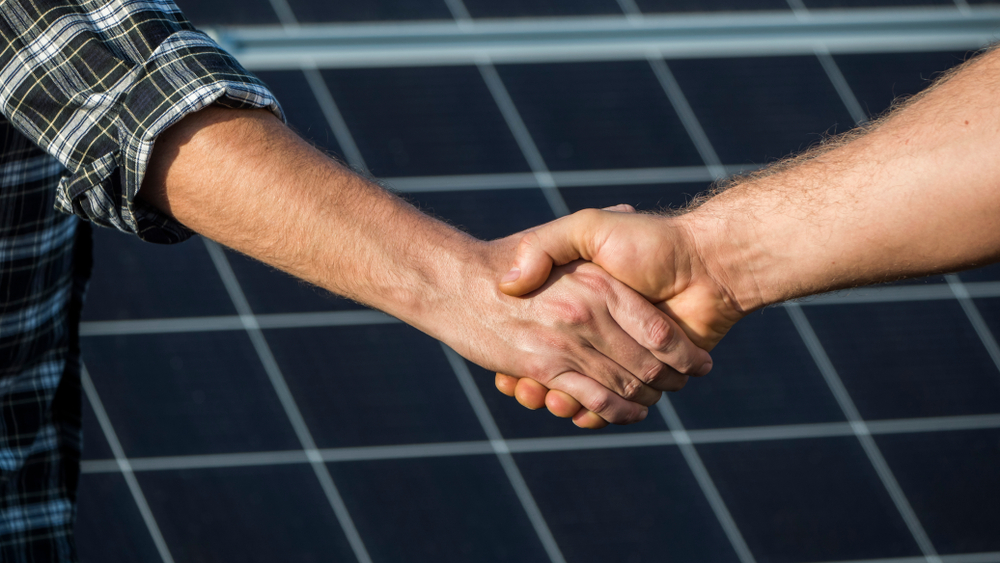 Handshake,Of,Two,Businessmen,On,A,Background,Surface,Of,Solar